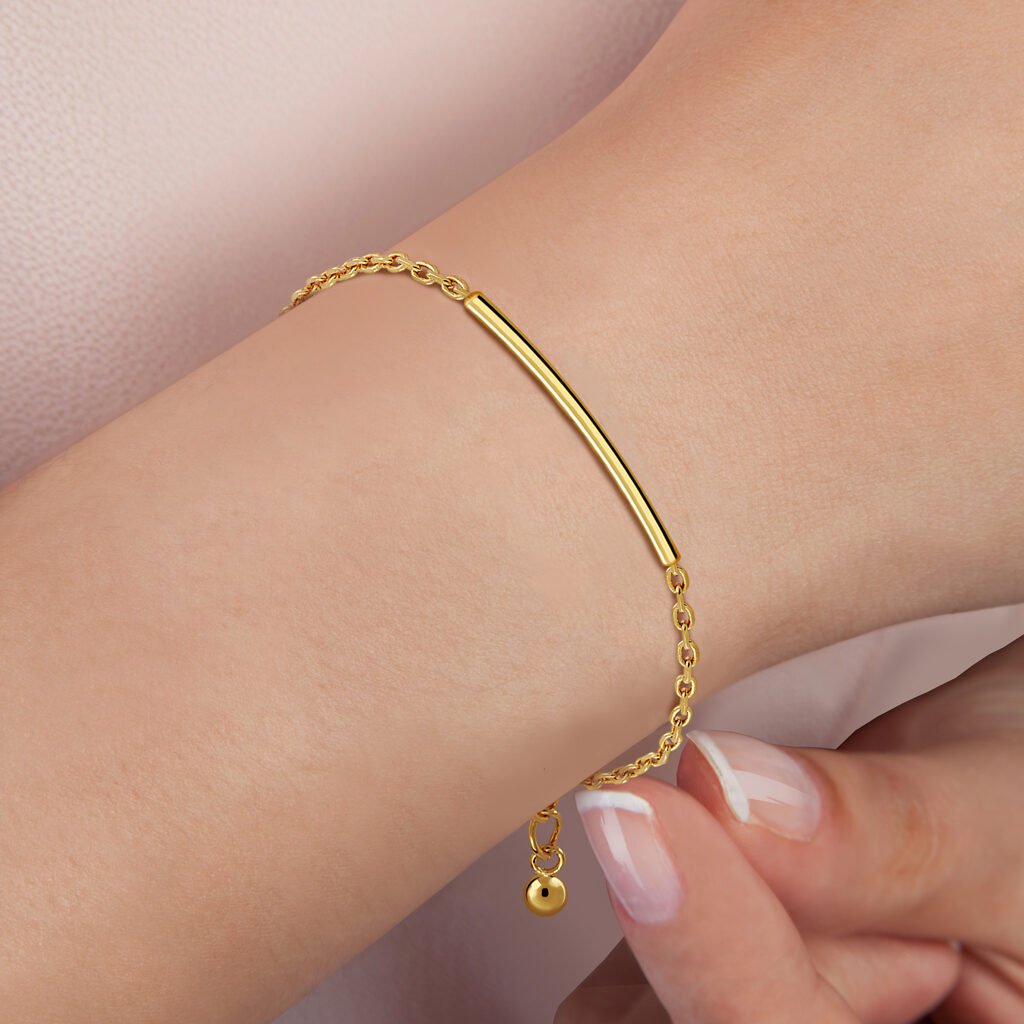 Mujer luciendo Pulsera Oro Lucía acabada en oro de 18 quilates