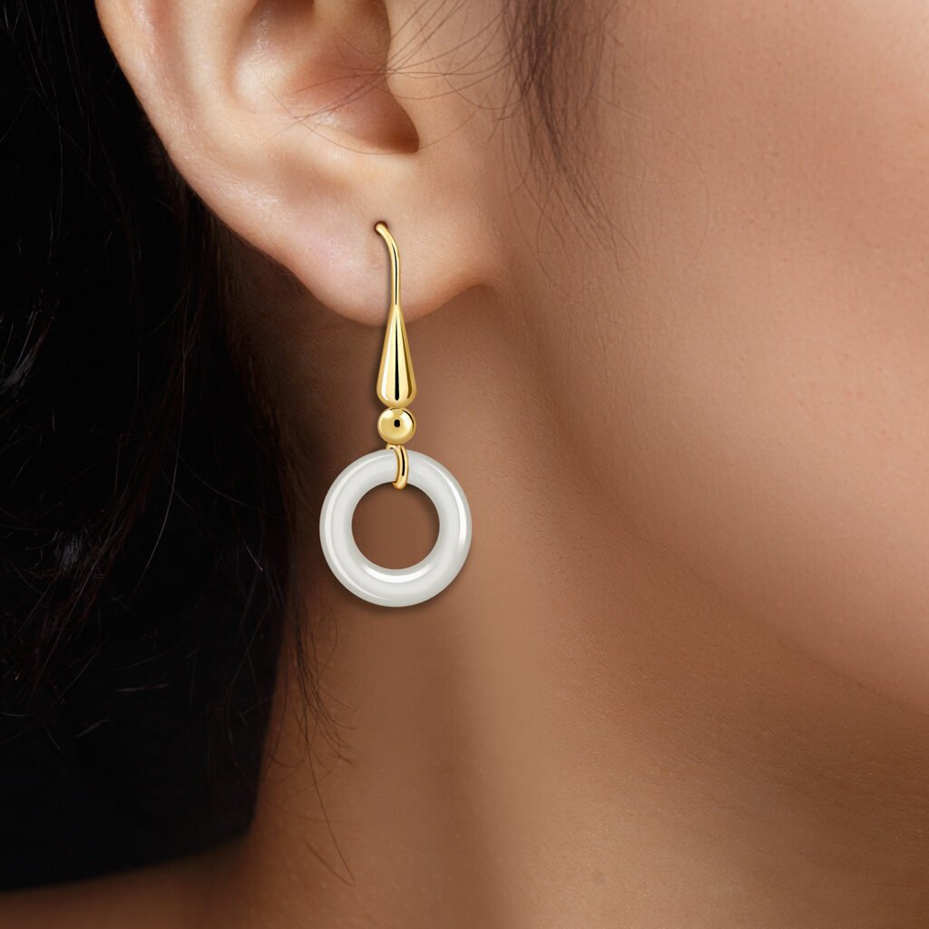 Mujer con Pendientes Oro Nina Ágata acabados en oro de 18 quilates y piedra tallada en forma de aro
