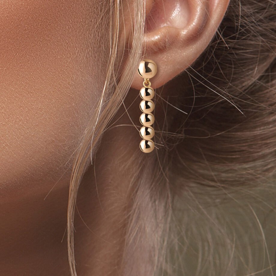 Chica rubia luciendo los Pendientes Oro Laia formados por pequeñas esferas